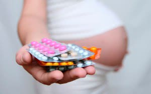 Беременная женщина с таблетками в руках