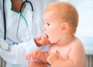 Врач производит гигиенические процедуры во рту у ребенка